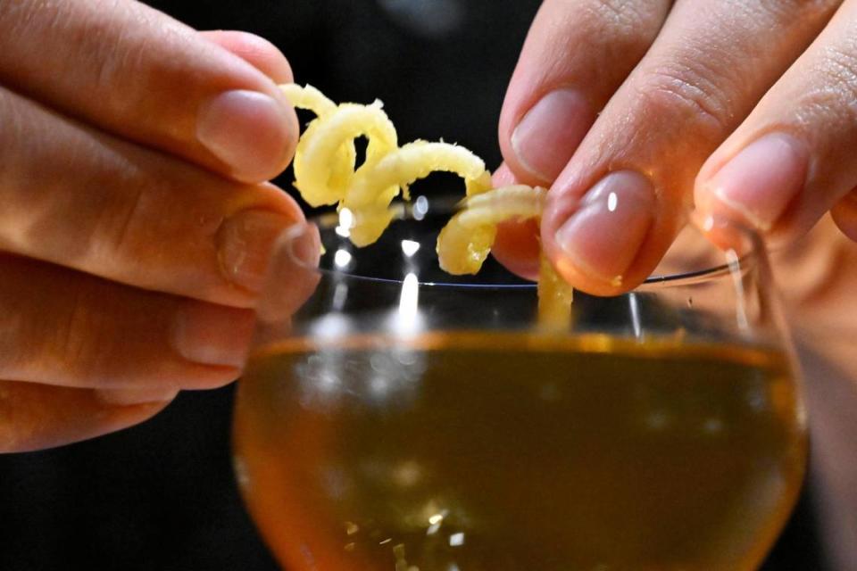 A curl of lemon is added to a drink at Bespoke, the new cocktail bar opened by Carmen Serrato and Po Tsai, located on Fulton Street in Fresno’s Brewery District. The bar, open to reservations only, offers a unique atmosphere. Photographed Monday, June 26, 2023 in downtown Fresno.