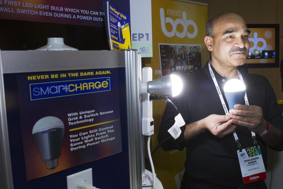 Founder Shailendra Suman poses with a SmartCharge LED lightbulb during "CES Unveiled," a media preview event to the annual Consumer Electronics Show (CES), in Las Vegas