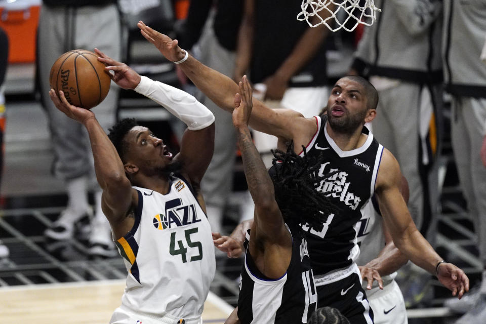 Utah Jazz guard Donovan Mitchell, left, shoots as Los Angeles Clippers forward Nicolas Batum, right, and guard Terance Mann defend during the second half of Game 3 of a second-round NBA basketball playoff series Saturday, June 12, 2021, in Los Angeles. (AP Photo/Mark J. Terrill)