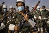 A Polisario Front soldier holds an AK-47 after a National Unity Day event in the Dajla refugee camp, Algeria, Tuesday, Oct. 12, 2021. (AP Photo/Bernat Armangue)