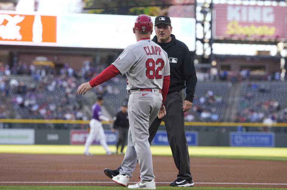 First base umpire Dan Bellino, right, talks briefly with St. Louis Cardinals first base coach Stubby Clapp at a baseball game Monday, April 10, 2023, in Denver. With the advent of the pitch clock in Major League Baseball this season, talk between players and umpires has almost been eliminated from the fabric of the sport. (AP Photo/David Zalubowski)