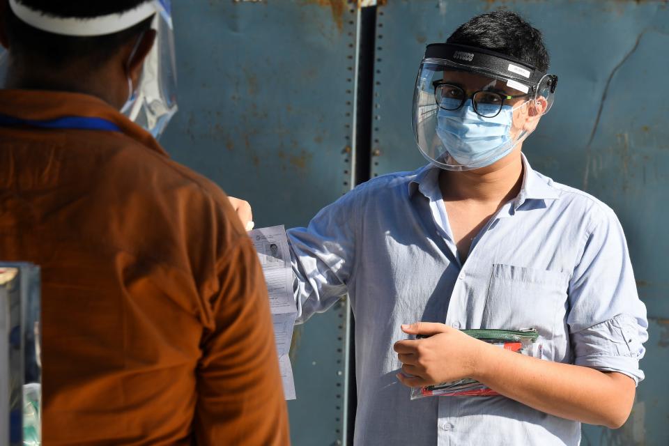 A student (R) arrives at an examination centre for Joint Entrance Examination (JEE ) Main-2020, one of the most competitive entrance exams for entry to top national engineering colleges, in Noida on September 1, 2020. (Photo by Prakash SINGH / AFP) (Photo by PRAKASH SINGH/AFP via Getty Images)