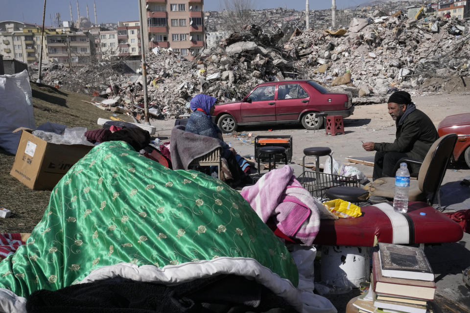 A Turkish man and his wife take rest after collecting belongings from their destroyed house in Kahramanmaras city, southern Turkey, Wednesday, Feb. 15, 2023. Thousands left homeless by a massive earthquake that struck Turkey and Syria a week ago packed into crowded tents or lined up in the streets for hot meals as the desperate search for survivors entered what was likely its last hours. (AP Photo/Hussein Malla)