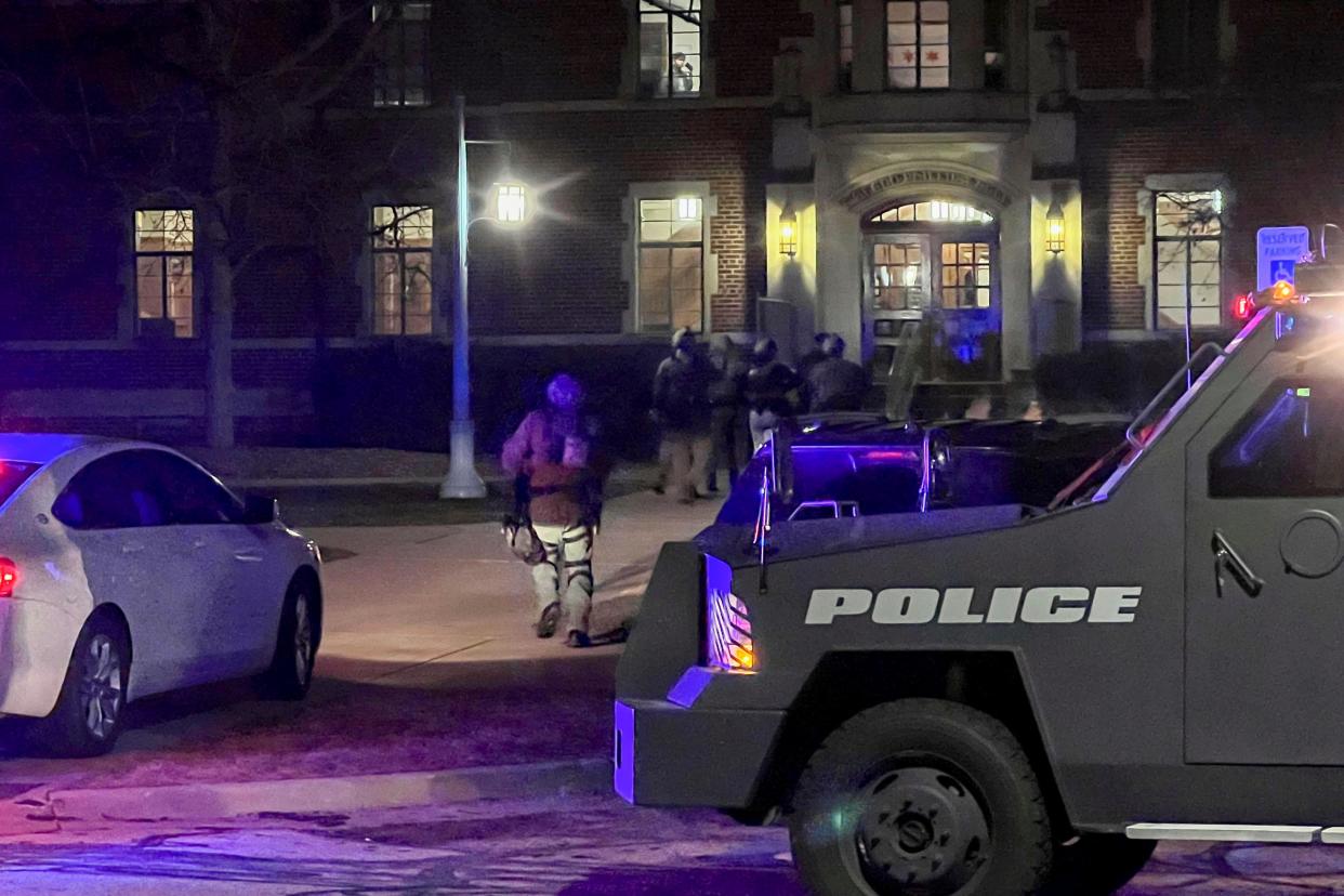 Armed police officers with weapons drawn rush into Phillips Hall on the campus of Michigan State University, in East Lansing, Michigan (AP)