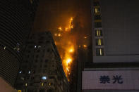 A fire burns at a construction site in Hong Kong, Friday, March 3, 2023. Hong Kong firefighters are battling the blaze that broke out at a construction site in the city's popular shopping district. (AP Photo/Louise Delmotte)