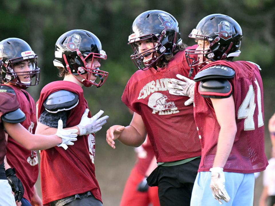 Cape Tech lineman Alex Riker (second from the right) gets support from his teammates after a particularly successful drill on Aug. 29, 2022, in Harwich.