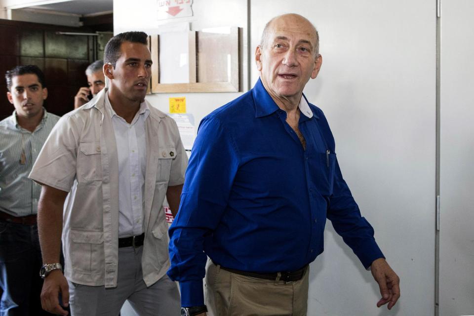 Israel's former Prime Minister Ehud Olmert, right, leaves the Tel Aviv District Court after his hearing in Israel, Tuesday, May 13, 2014. Olmert was sentenced on Tuesday to six years in prison for his role in wide-ranging bribery case, capping a stunning fall from grace for one of the most powerful men in the country. (AP Photo/Jack Guez, Pool)