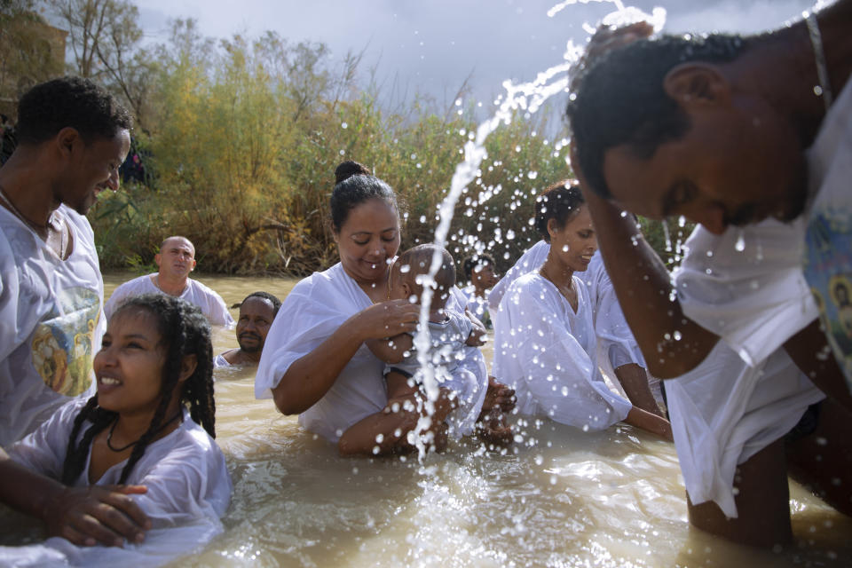 Members of the Eritrean and Ethiopian Christian Orthodox community from Tel Aviv participate in a baptismal ceremony in the waters of the Jordan River as part of the Orthodox Feast of the Epiphany at the Qasr al-Yahud baptismal site, near the West Bank town of Jericho on Friday, Jan. 19, 2018. (AP Photo/Oded Balilty)