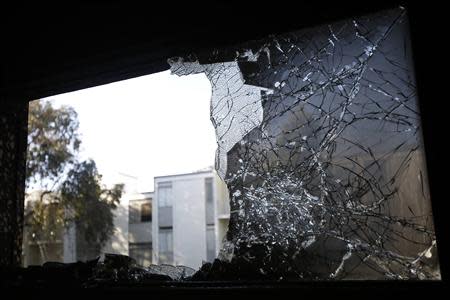 A broken window is seen at the Chinese consulate after an unidentified person set fire to the main gate in San Francisco, California January 2, 2014. REUTERS/Stephen Lam