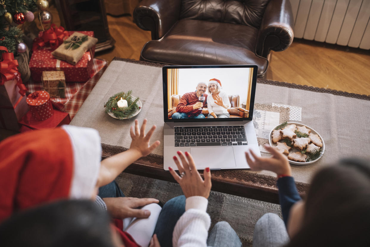 Family and their children wave with hand in video call on Christmas. (Getty Images)