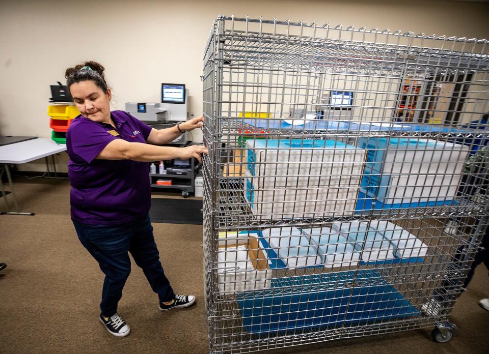 Supervisor of Elections employee Lizbeth Padilla pulls a locked cart containing Lake Wales ballots to be recounted at the Polk Supervisor of Elections Office in Winter Haven on Friday.