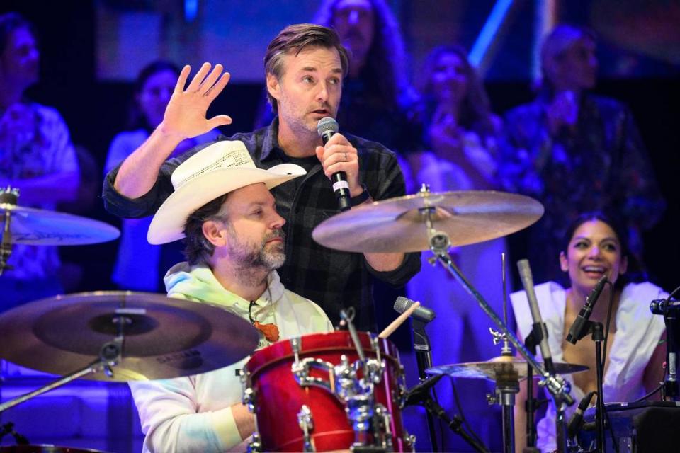 Comedian Will Forte takes the mic as fellow “Saturday Night Live” alum Jason Sudeikis, aka Ted Lasso, shows off another talent, playing the drums, during the Big Slick show and auction.