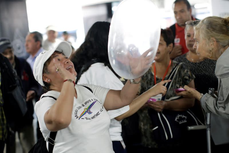 Una voluntaria sostiene un condón inflado durante un evento organizado por AHF para el Día Internacional del Condón, en una estación del Metro en Ciudad de México