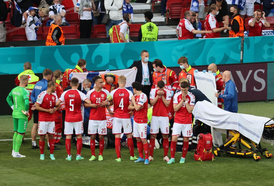 Denmark players shield Christian Eriksen while he receives medical attention (Reuters)