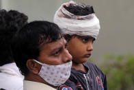 A man carries Mohammed Bangi, a four-year-old boy, as he leaves a hospital after he was rescued from the rubble at the site of a collapsed five-storey building in Mahad in Raigad district in the western state of Maharashtra. REUTERS/Francis Mascarenha