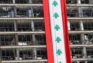 A big Lebanese flag is seen on a damaged building in Beirut