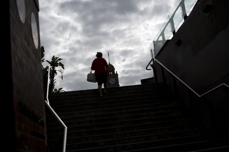 A woman emerges from a underground walkway near the Central train station in the business district of Sydney on April 5, 2013. Australian Prime Minister Julia Gillard on Monday warned voters to brace for an austere election-year budget, unveiling a Aus$12 billion (US$12.4 billion) slump in revenues due to the strong dollar