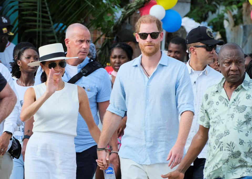 Britain's Prince Harry and his wife Meghan, Duchess of Sussex, walk together in San Basilio de Palenque, Colombia (REUTERS)