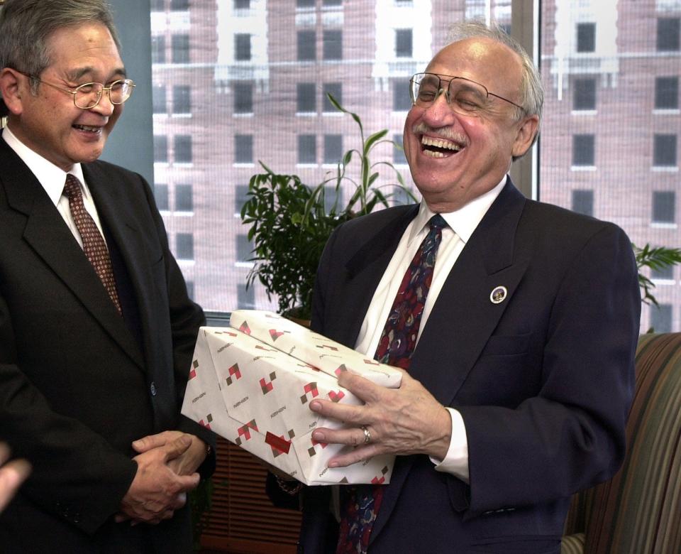 New Lansing Mayor Tony Benavides laughs in his office after exchanging small gifts with Yasuo Nishikawa, left, senior managing director, and others from a visiting delegation from Otsu City, Shiga Prefecture, Japan, in 2003. Otsu is one of Lansing's Sister Cities.