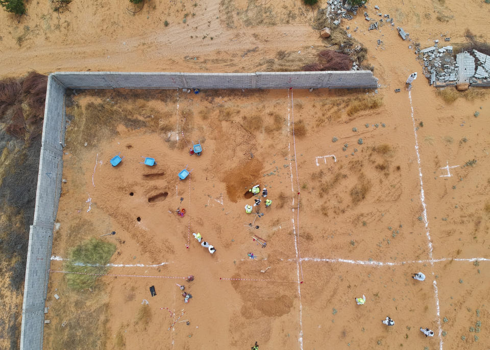 Libyan Ministry of justice employees dig out at a siyte of a suspected mass grave in the town of Tarhouna, Libya, Tuesday, June 23, 2020. The United Nations said that at least eight mass graves have been discovered, mostly in Tarhuna, a key western town that served as a main stronghold for Khalifa's east-based forces in their 14-month campaign to capture the capital, Tripoli. (AP Photo/Hazem Ahmed)