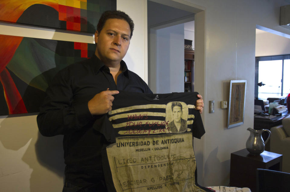 Sebastian Marroquin, son of Colombia's late drug lord Pablo Escobar, shows a shirt from his new clothing line "Escobar Henao," which reads in Spanish "What's your future looking like?" and displays his late father's high school identification card, at his home in Buenos Aires, Argentina, Friday, Aug. 17, 2012. Marroquin, who legally changed his name and moved to Argentina in 1994 with his mother Maria Valeria Henao after his father, says he created the collection as a way to send a message of peace and reflection about his family's history. (AP Photo/Eduardo Di Baia)