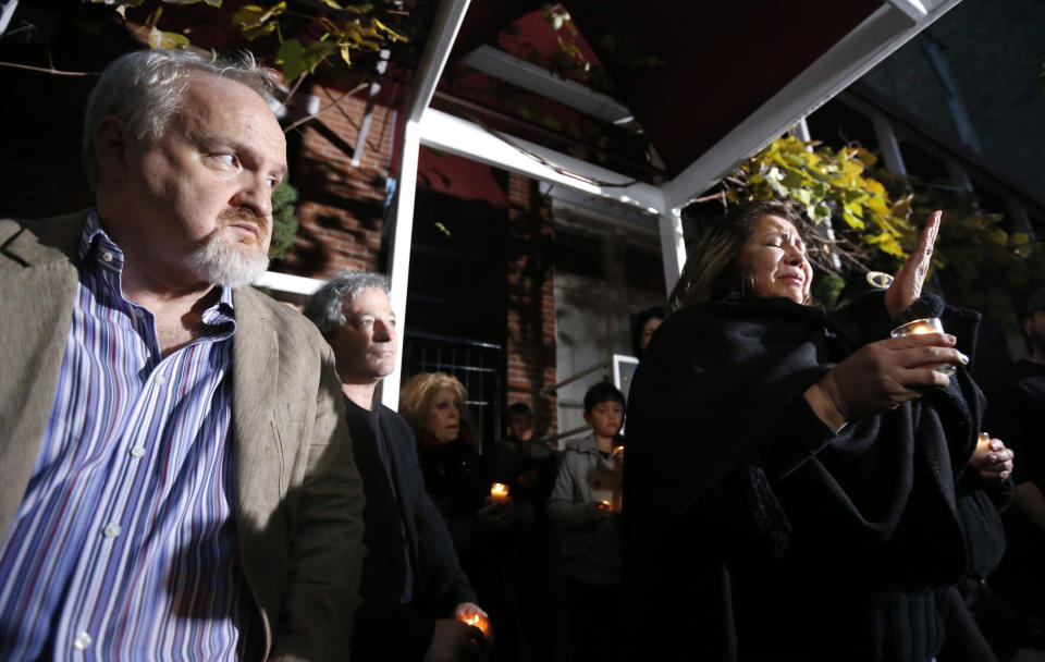Chef Art Smith, left, watches Chef Priscila Satkoff fight back tears as she pays tribute to Chicago Chef Charlie Trotter during a candlelight memorial for Trotter outside his former restaurant Tuesday, Nov. 5, 2013, in Chicago. Trotter, 54, died Tuesday, a year after closing his namesake Chicago restaurant that was credited with putting his city at the vanguard of the food world and training dozens of the nation's top chefs, including Grant Achatz and Graham Elliot. (AP Photo/Charles Rex Arbogast)