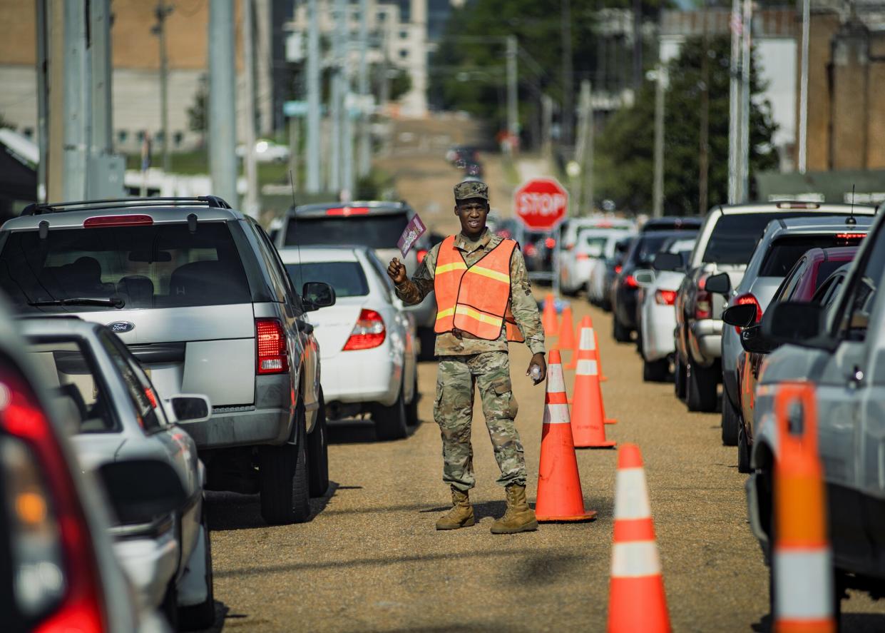 A member of the National Guard directs vehicles arriving at a water distribution site during a water shortage in Jackson, Mississippi, US, on Friday, Sept. 2, 2022. The governor of Mississippi called in the National Guard to help residents of the state capital after a plant failure left at least 180,000 people in the area without access to safe water.