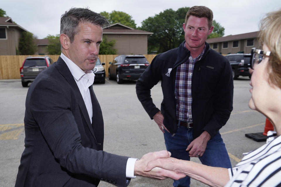 Rep. Adam Kinzinger, R-Ill., left, shakes hands with Linda Thomas right, as Texas congressional candidate Michael Wood looks on Tuesday, April 27, 2021, in Arlington, Texas. Wood is considered the anti-Trump Republican Texas congressional candidate that Kinzinger has endorsed in the May 1st special election for the 6th Congressional District. (AP Photo/LM Otero)