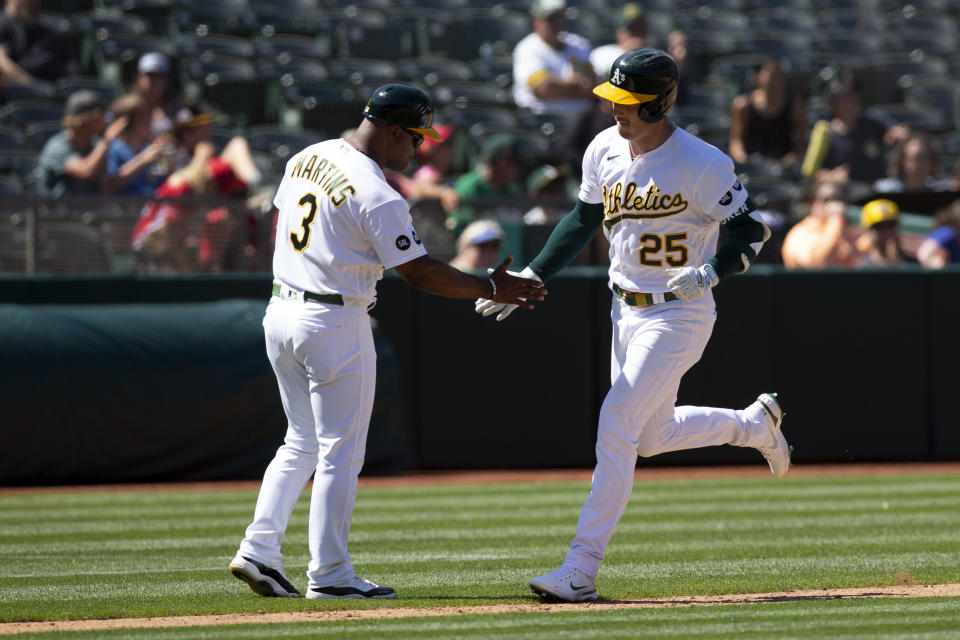Oakland Athletics' fielder Brent Rooker (25) gets a congratulatory handshake from third base coach Eric Martins (3) as he runs out his two-run home run against the Chicago White Sox during the eighth inning of a baseball game, Sunday, July 2, 2023, in Oakland, Calif. (AP Photo/D. Ross Cameron)