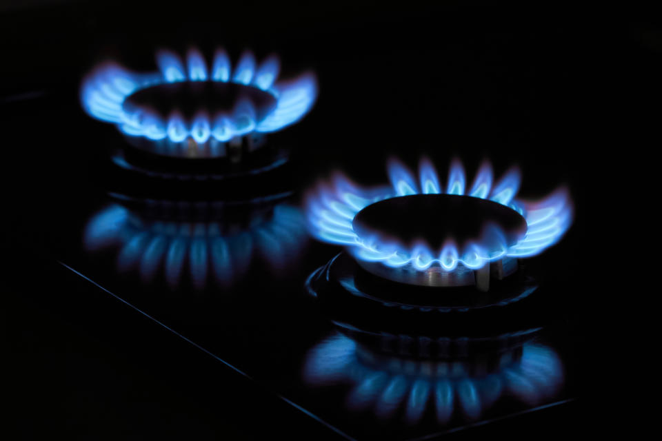 Flaming gas burners on household kitchen stove in the darkness