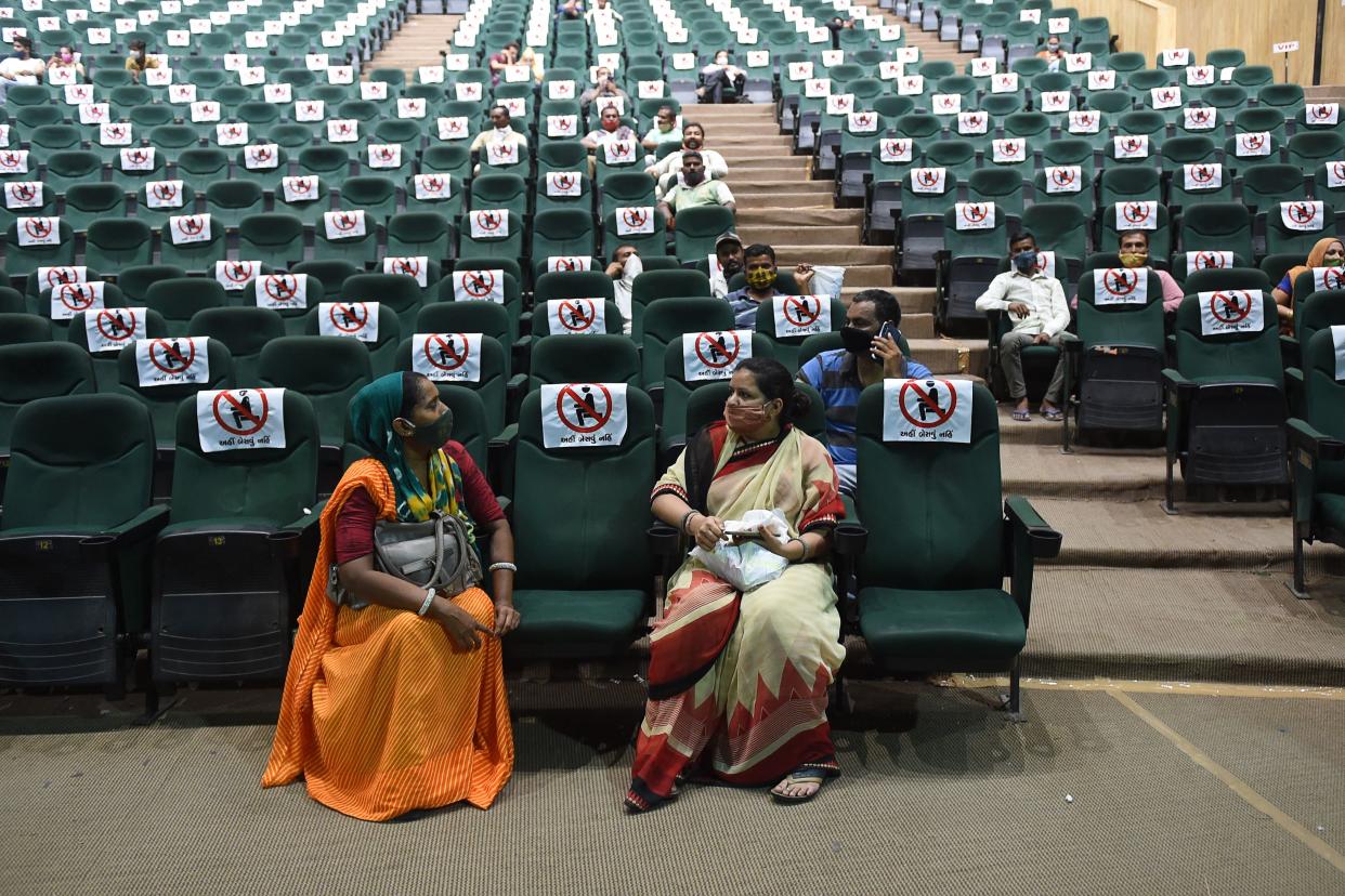 TOPSHOT - People sit after getting a dose of the Covishield vaccine against the Covid-19 coronavirus during a vaccination drive at Tagore Hall in Ahmedabad on July 6, 2021. (Photo by SAM PANTHAKY / AFP) (Photo by SAM PANTHAKY/AFP via Getty Images)