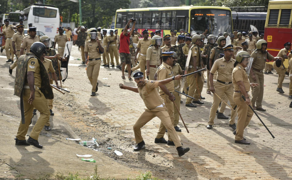 A policeman throws back a stone as they clash with protestors who tried to stop women of menstruating age from going to the Sabarimala temple at Nilackal, a base camp on way to the mountain shrine in Kerala, India, Wednesday, Oct. 17, 2018. The historic mountain shrine, one of the largest Hindu pilgrimage centers in the world is set to open its doors to females of menstruating age following a ruling by the country's top court. Police arrested some protesters when they tried to block the path of some females. (AP Photo)