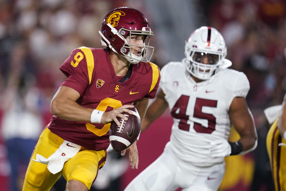 Southern California quarterback Kedon Slovis (9) runs out of the pocket as Stanford linebacker Ricky Miezan (45) pursues during the first half of an NCAA college football game Saturday, Sept. 11, 2021, in Los Angeles. (AP Photo/Marcio Jose Sanchez)