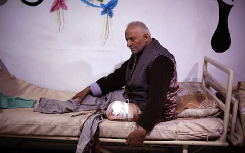 A Syrian man wounded in air strikes receives treatment at a make-shift hospital in Eastern Ghouta  - Credit: AMER ALMOHIBANY/AFP/Getty Images