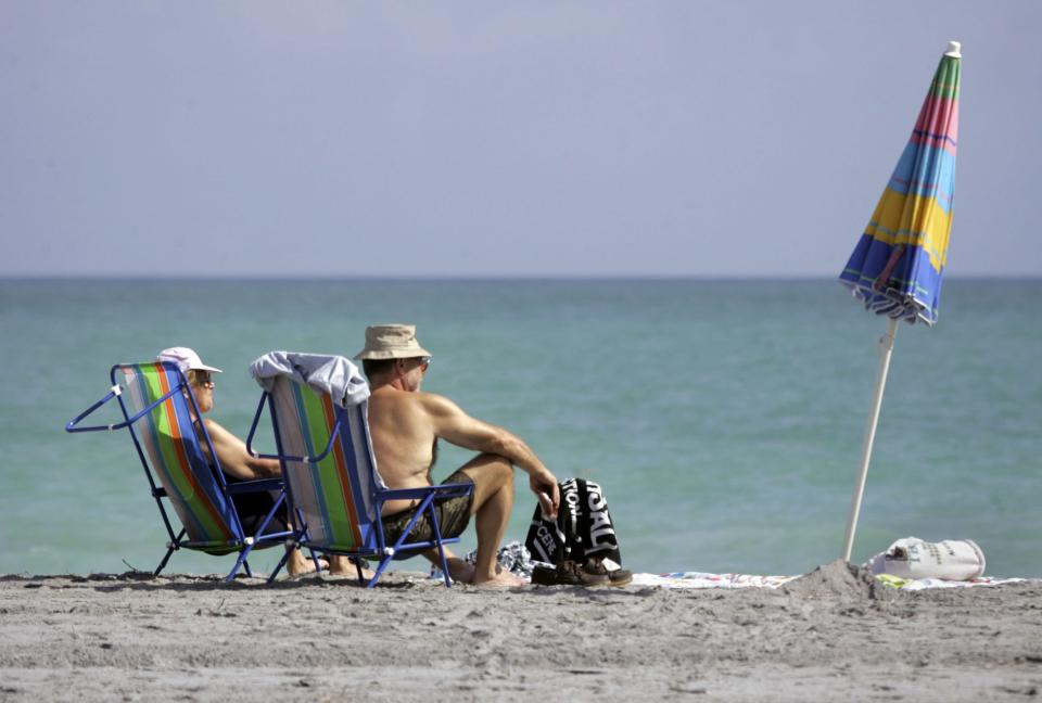 Canadians Gilles Dupont, left, and Monique Dupont sit in the sun, Tuesday, Jan. 24, 2006, in Dania Beach, Fla.   Temperatures at the Dupont's home in Valley Field, a small town southwest of Montreal, were in the low-30s midday Tuesday. 