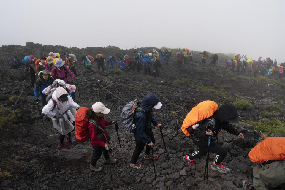 People climb to the summit of Mount Fuji, Monday, Aug. 26, 2019, in Japan. It takes an average hiker five to six hours to reach the summit. (AP Photo/Jae C. Hong)