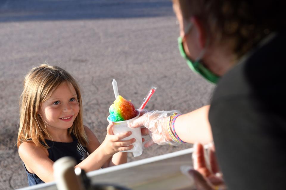 Lucy Smith, 6, receives a rainbow shaved ice from Finnley Johnson on Thursday, July 9, in Sioux Falls.