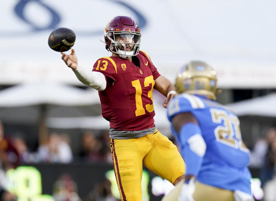 Southern California quarterback Caleb Williams, left, throws a pass as UCLA linebacker JonJon Vaughns watches during the second half of an NCAA college football game Saturday, Nov. 18, 2023, in Los Angeles. (AP Photo/Ryan Sun)