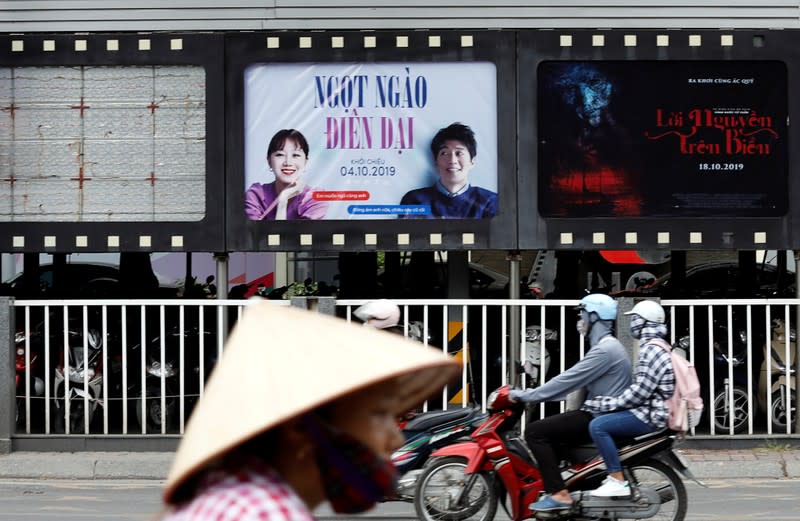 FILE PHOTO: Bikers go past an empty space where a promotional poster for the DreamWorks film "Abominable" stood before being taken down at a cinema in Hanoi