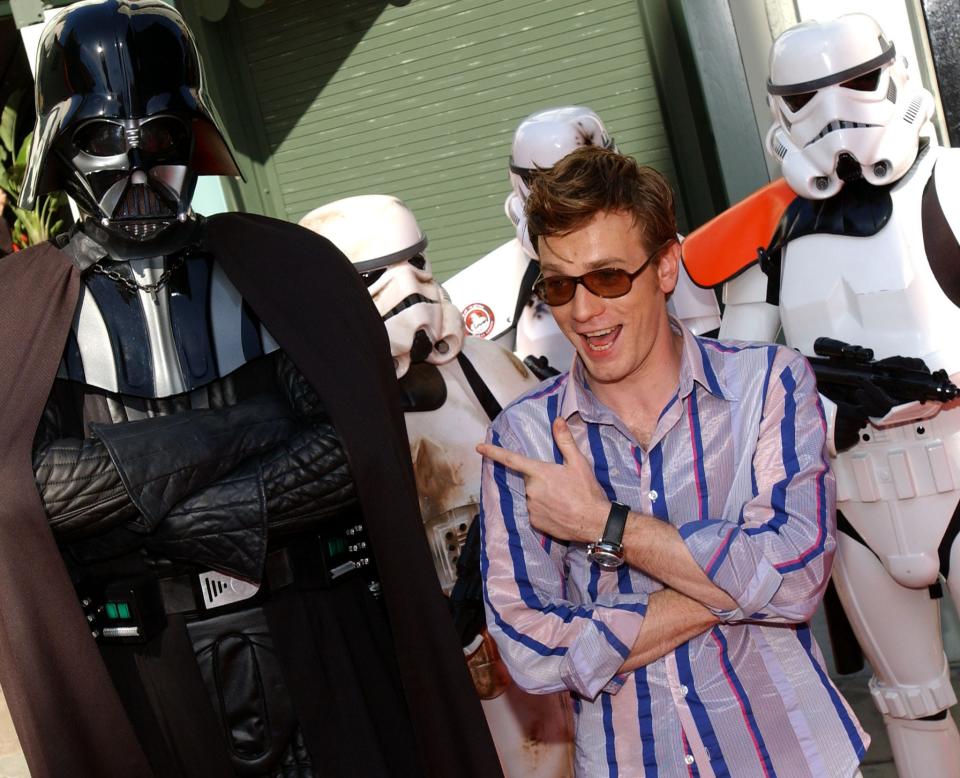 Scottish actor Ewan McGregor, star of "Star Wars: Episode II Attack of the Clones," poses at the film's premiere with Darth Vader and Storm Troopers in Los Angeles,CA 12 May 2002.