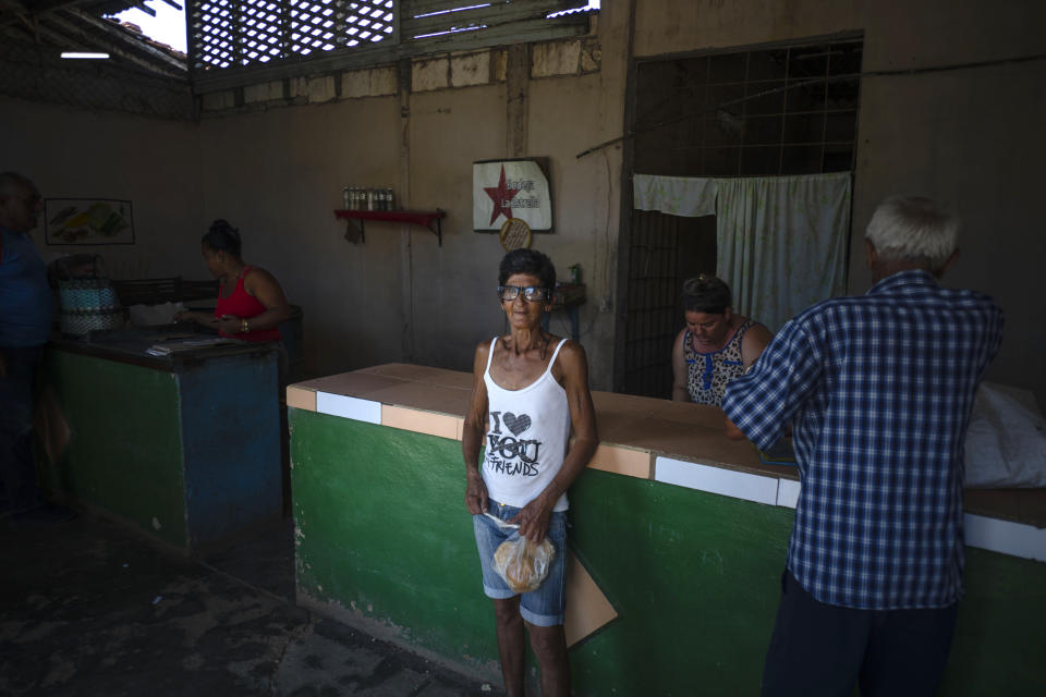 Surunvey Gonzalez poses for a photo at the government subsidized store, or "bodega," where she picked up her ration of bread in San Nicolas, Cuba, Friday, May 19, 2023. With food and medications already in short supply amid the recent economic crisis, the latest fuel shortages are being perceived as the last straw by many residents in small villages far from the capital. (AP Photo/Ramon Espinosa)