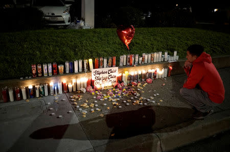 FILE PHOTO: A man pauses at a sidewalk memorial to Stephon Clark, in Sacramento, California, U.S. March 23, 2018. REUTERS/Bob Strong/File Photo