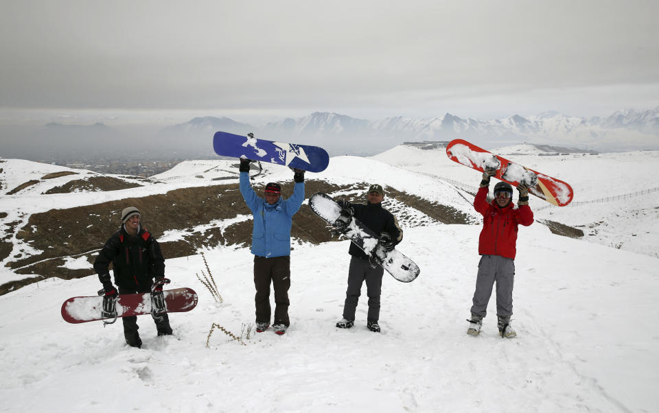 In this Friday, Jan. 24, 2020 photo, Ahmad Sorush, 22, left, Nizaruddin Alizada, 20, Karim Faizi, 24, and Mohammad Farzad, 20, members of the Afghanistan Snowboarding Federation pose for photograph during a practice session on the outskirts of Kabul, Afghanistan. While Afghanistan’s capital may seem an unlikely destination for snowboarders, a group of young Afghans is looking to put the city on the winter sports map and change perceptions about their war-weary nation. (AP Photo/Rahmat Gul)