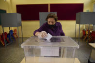 A woman casts her ballot at a polling station during Turkish Cypriots election for a new leader in the Turkish occupied area in the north part of the divided capital Nicosia, Cyprus, Sunday, Oct. 18, 2020. Turkish Cypriots began voting Sunday in a leadership runoff to choose between an incumbent who pledges a course less bound by Turkey’s dictates and a challenger who favors even closer ties to Ankara. (AP Photo/Nedim Enginsoy)