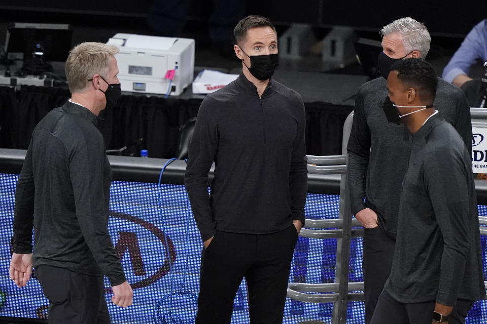 Brooklyn Nets coach Steve Nash, center, talks with Golden State Warriors coach Steve Kerr, left, and other coaches before an NBA basketball game, Nash's debut in the regular season, Tuesday, Dec. 22, 2020, in New York. (AP Photo/Kathy Willens)