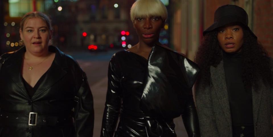 Theodora, Arabella and Terry wear black and walk down the street at night