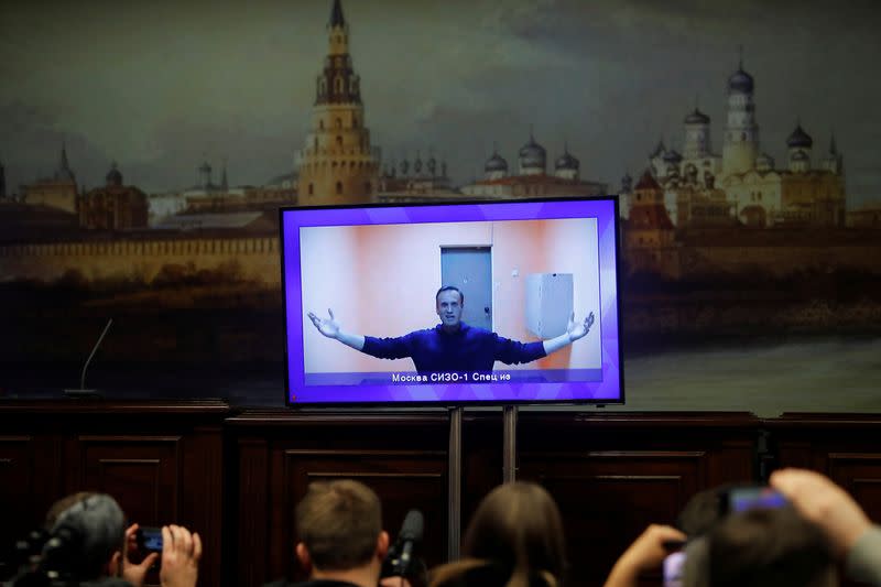 FILE PHOTO: Russian opposition leader Alexei Navalny is seen on a screen via a video link during a court hearing to consider an appeal on his arrest, outside Moscow