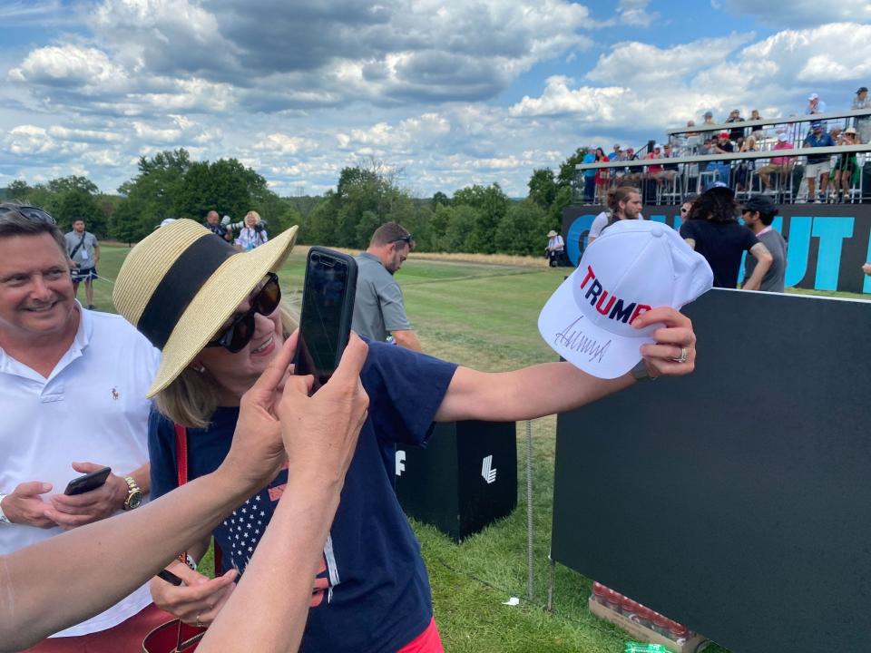 A woman celebrates with her newly signed Trump hat.