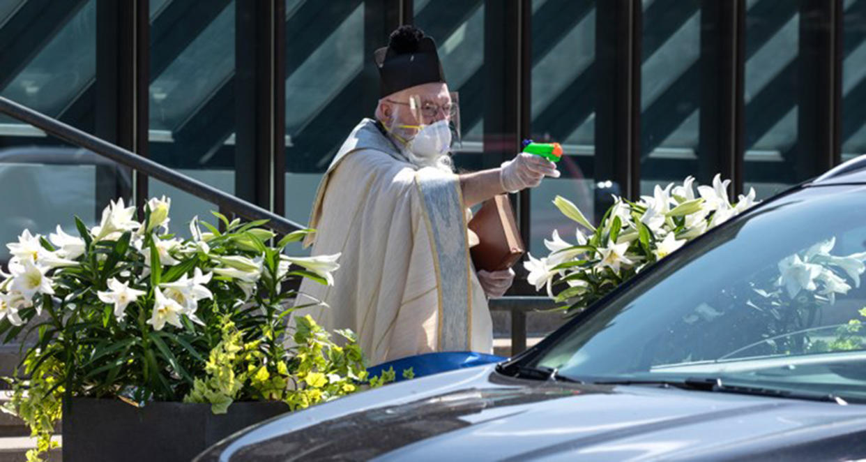 priest uses squirt gun (Larry Peplin)