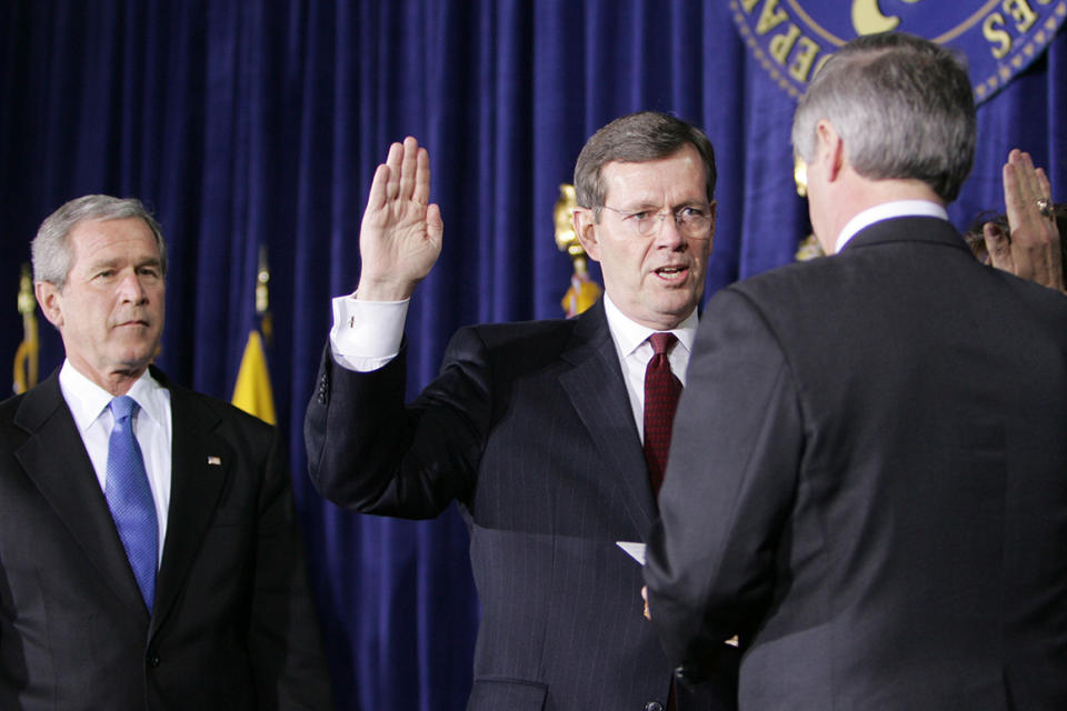 President Bush, left watches new Secretary of Health and Human Services Mike Leavitt, center, take part in a swearing-in ceremony for Leavitt, Friday, Feb. 11, 2005, at the Health and Human Services headquarters in Washington. White House Chief of Staff Andrew Card, right, swears in Leavitt.  (AP Photo/Ron Edmonds)